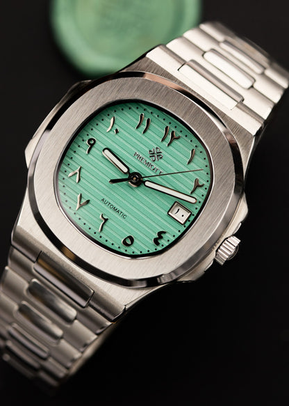 The Heritage cu cadran verde mentă și cifre arabe, carcasă din oțel, sigiliu de ceară turcoaz în fundal