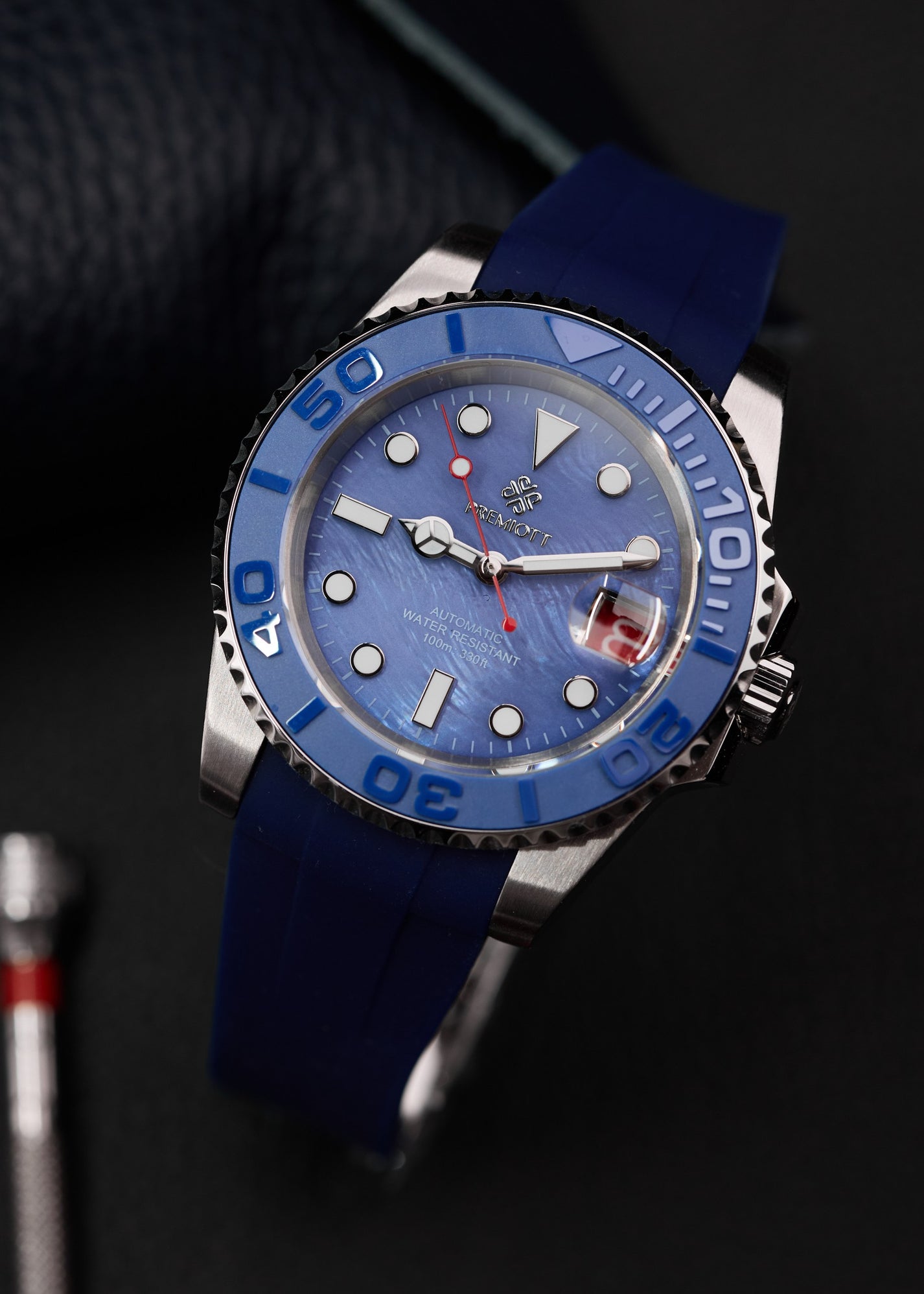 The Mariner cu cadran albastru, bezel ceramic albastru și curea din cauciuc albastru, fundal negru