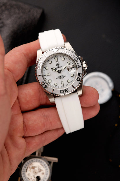 The Mariner cu cadran alb sidefat, bezel ceramic alb și curea din cauciuc alb, ținut în mână