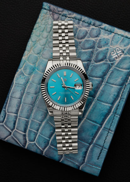 The Just Date, ceas automatic personalizat cu cadran turcoaz, carcasa otel, bratara Jubilee, pe piele crocodil bleu.