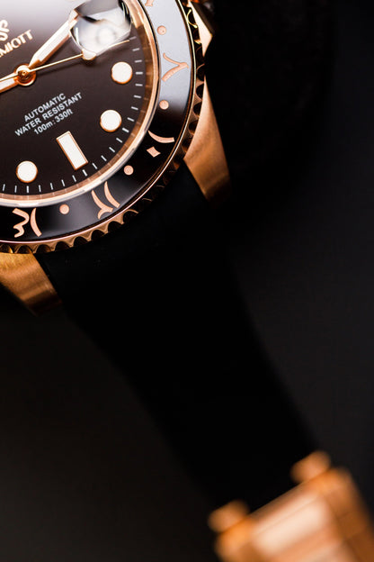Detaliu cadran și bezel aurii The Mariner, prim-plan diagonal cu curea din cauciuc negru
